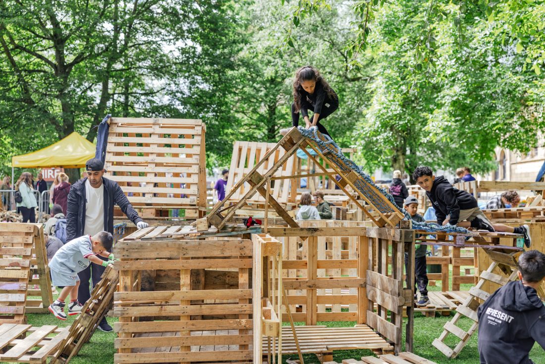 Photo of children playing on climbing frames made from upcycled packing crates.