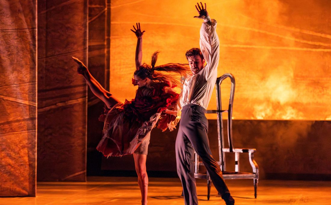 Photo of a male and female ballet dancer performing on a fiery orange stage.