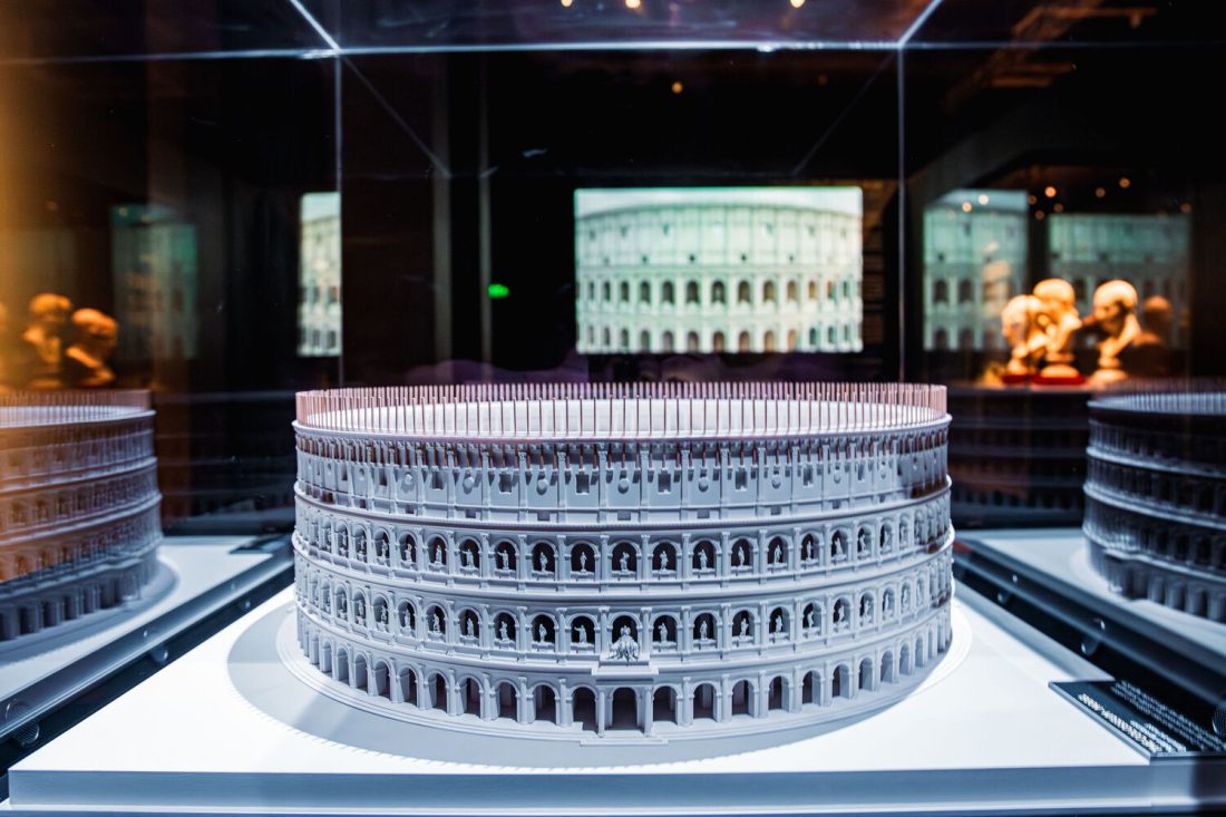 Photo of a model of a Roman colosseum inside a glass museum case.