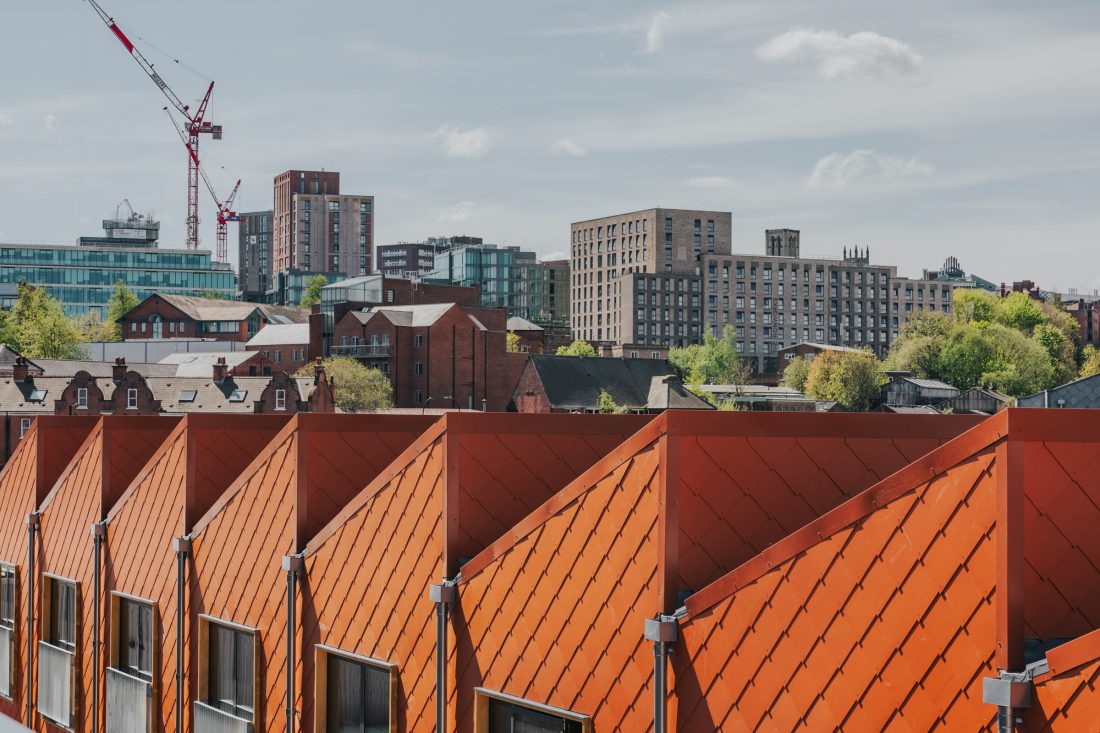 Photo of a cityscape with cheerful, orange apartments in the foreground.