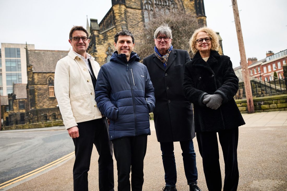 Photo of four people, including Poet Laureate Simon Armitage, standing outside with coats on, smiling at the camera.